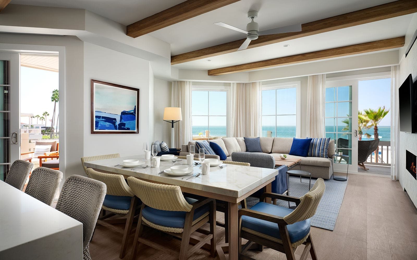 Living area with sofa and balcony with palm and ocean view at Hotel del Coronado